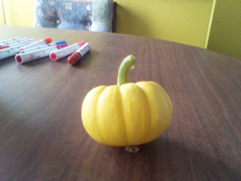 A miniature pumpkin on a table
